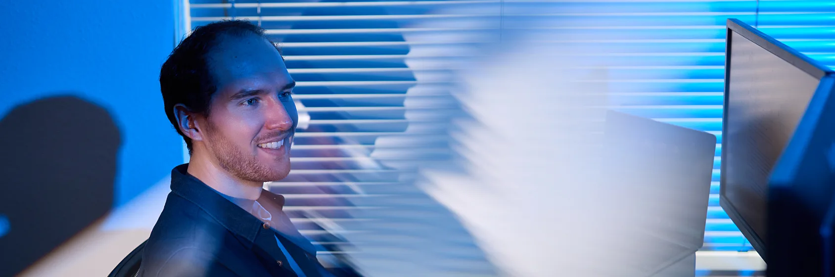 dawn technology man developer werknemer collega achter computerscherm op kantoor sfeerbeeld
