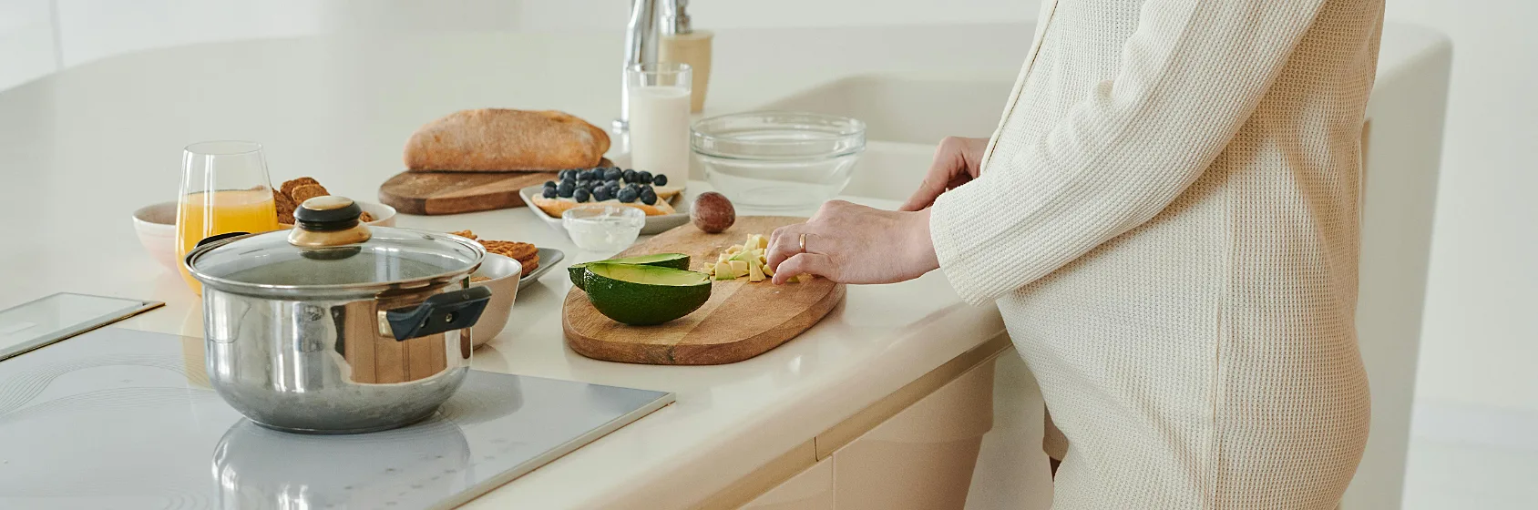 Zwangere dame die eten klaarmaakt aan het aanrecht