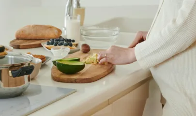 Zwangere dame die eten klaarmaakt aan het aanrecht